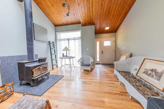 foyer featuring wood ceiling, a wood stove, and light hardwood / wood-style floors