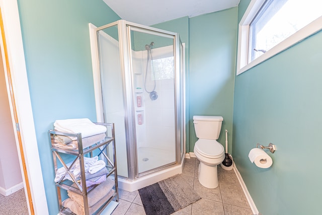 bathroom with toilet, tile patterned flooring, and a shower with door