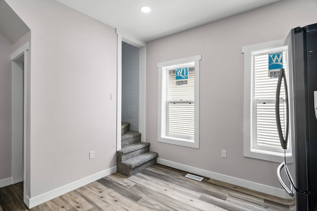 empty room with a healthy amount of sunlight and hardwood / wood-style floors