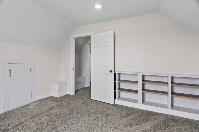 additional living space with lofted ceiling and dark colored carpet