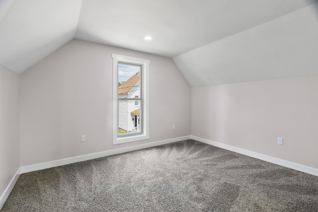 additional living space with carpet floors and vaulted ceiling