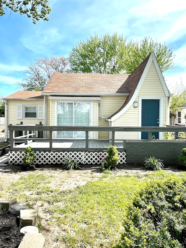 rear view of property featuring a wooden deck and a yard