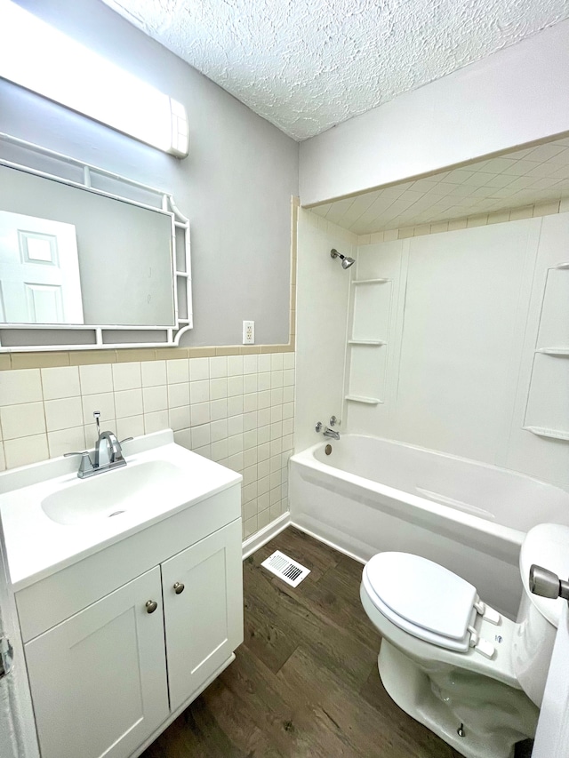 full bathroom with toilet, a textured ceiling, tile walls, vanity, and hardwood / wood-style flooring