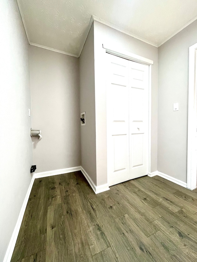 laundry room with dark wood-type flooring, crown molding, and hookup for a washing machine