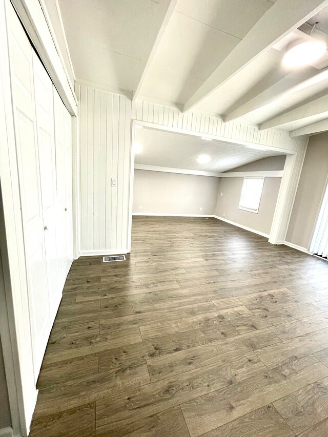 interior space featuring beamed ceiling and dark wood-type flooring