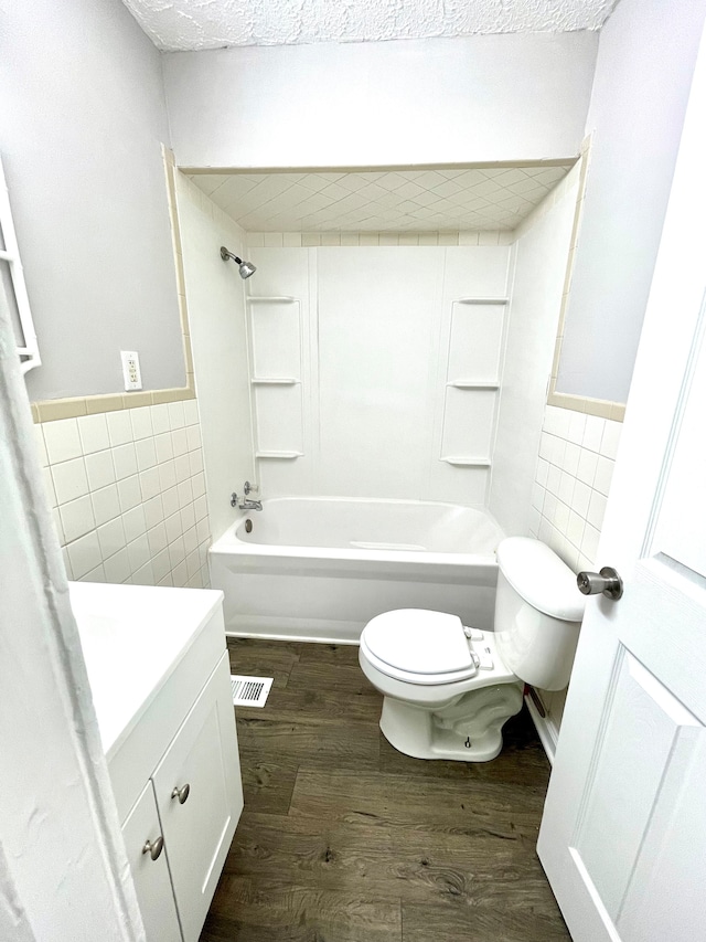 full bathroom featuring wood-type flooring, tile walls, vanity, and toilet