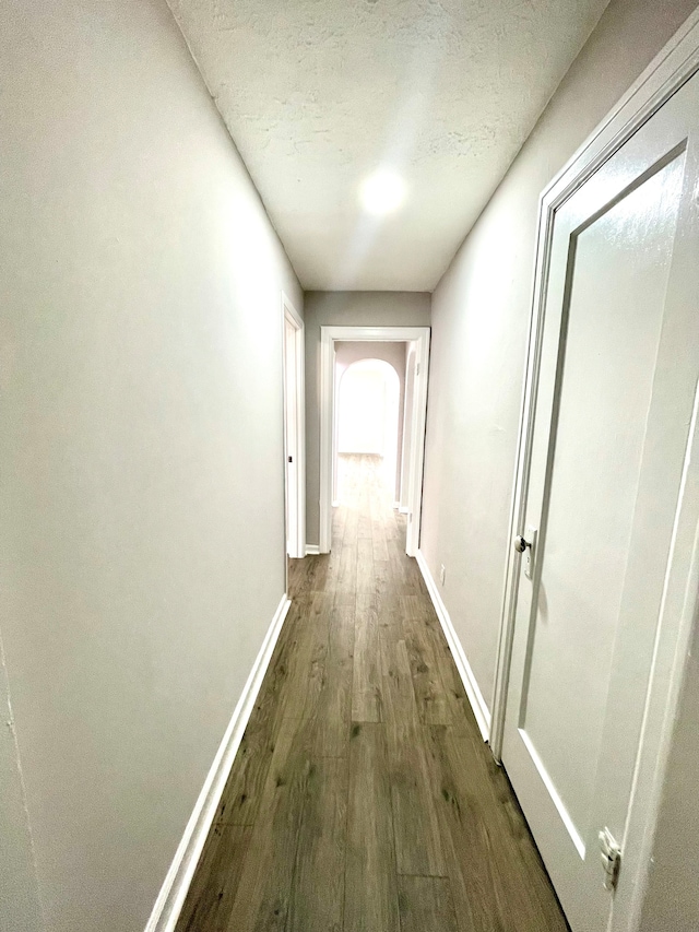 hallway featuring dark hardwood / wood-style floors and a textured ceiling