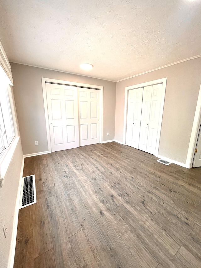 unfurnished bedroom with dark hardwood / wood-style floors and a textured ceiling