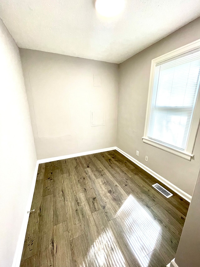 unfurnished room with hardwood / wood-style flooring and a textured ceiling