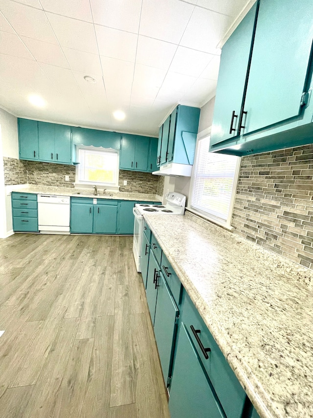 kitchen featuring sink, decorative backsplash, white appliances, and light hardwood / wood-style floors