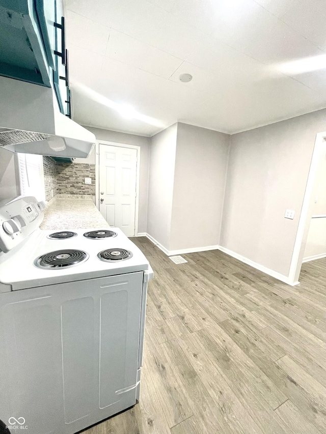 kitchen with tasteful backsplash, light hardwood / wood-style flooring, and electric stove