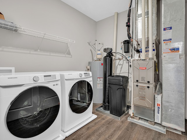 laundry area with gas water heater, dark hardwood / wood-style floors, and washer and dryer