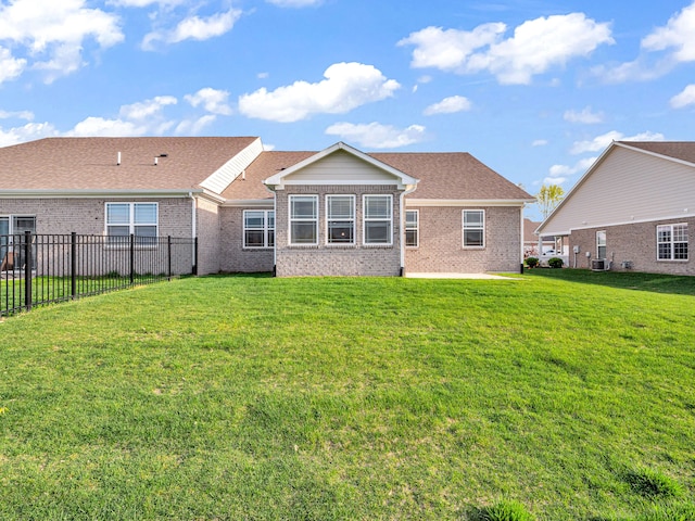 rear view of property with a yard and central air condition unit