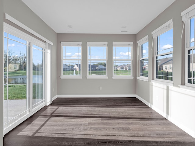 unfurnished sunroom with a healthy amount of sunlight and a water view