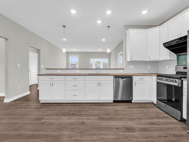 kitchen featuring hardwood / wood-style flooring, kitchen peninsula, appliances with stainless steel finishes, and tasteful backsplash