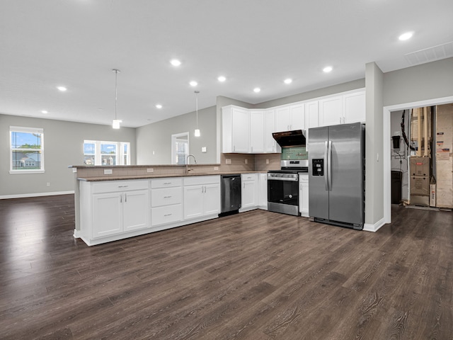 kitchen featuring kitchen peninsula, hanging light fixtures, backsplash, stainless steel appliances, and dark hardwood / wood-style flooring