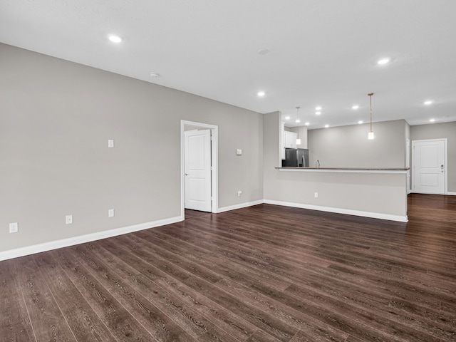 unfurnished living room with dark hardwood / wood-style flooring and sink