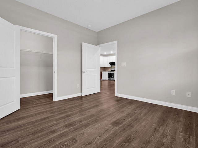 unfurnished bedroom featuring a closet and dark hardwood / wood-style flooring