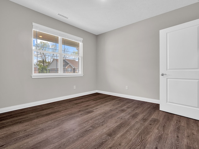 empty room with dark wood-type flooring