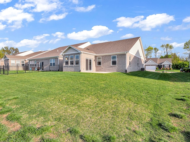 rear view of property with a garage and a lawn