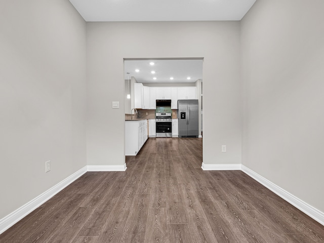 unfurnished living room featuring sink and dark wood-type flooring