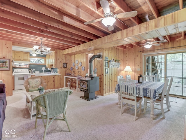 6486 Coyote Dr, Nineveh, IN 46164 - dining space with a wood stove, plenty of natural light, ceiling fan, light carpet, and wood walls