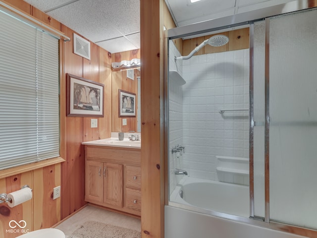6486 Coyote Dr, Nineveh, IN 46164 - full bathroom featuring wood walls, shower / bath combination with glass door, vanity, tile patterned flooring, and a paneled ceiling