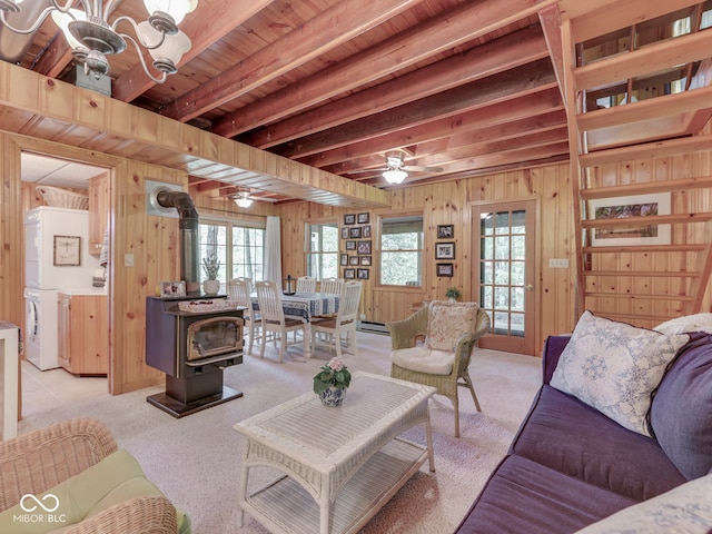 6486 Coyote Dr, Nineveh, IN 46164 - living area with washing machine and clothes dryer, healthy amount of natural light, wooden walls, a wood stove, and beam ceiling