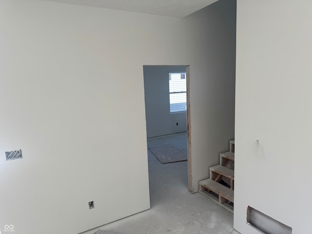 stairs featuring a textured ceiling and concrete floors