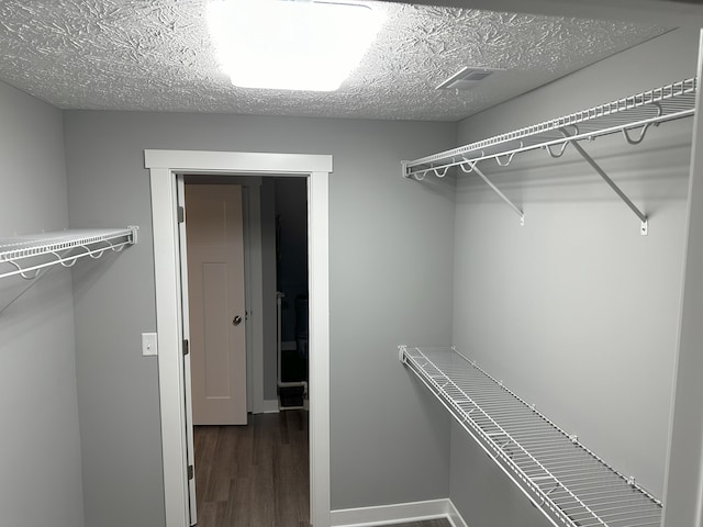 spacious closet featuring dark hardwood / wood-style floors