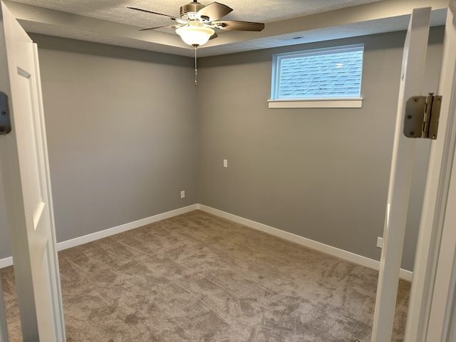 carpeted empty room featuring a textured ceiling and ceiling fan