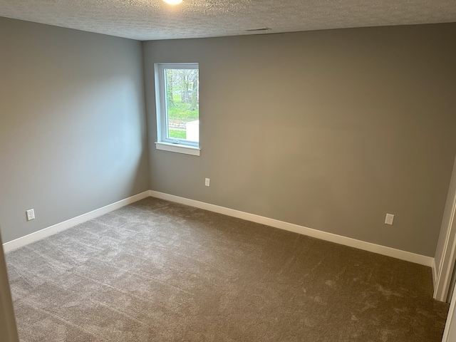 carpeted empty room with a textured ceiling