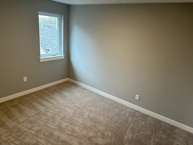 carpeted empty room with a textured ceiling