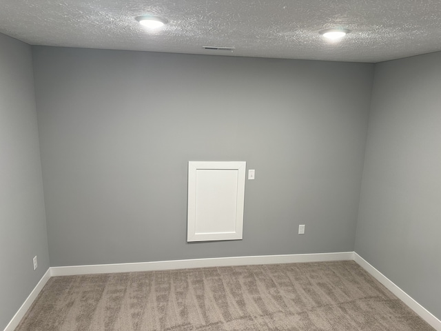 carpeted spare room featuring a textured ceiling