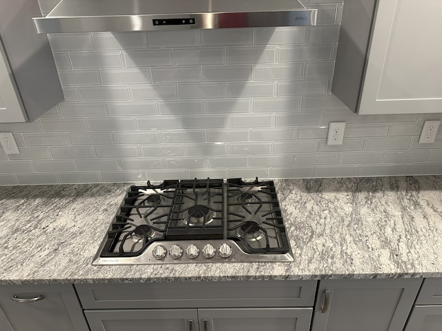 kitchen with gas cooktop, light stone countertops, decorative backsplash, and gray cabinets