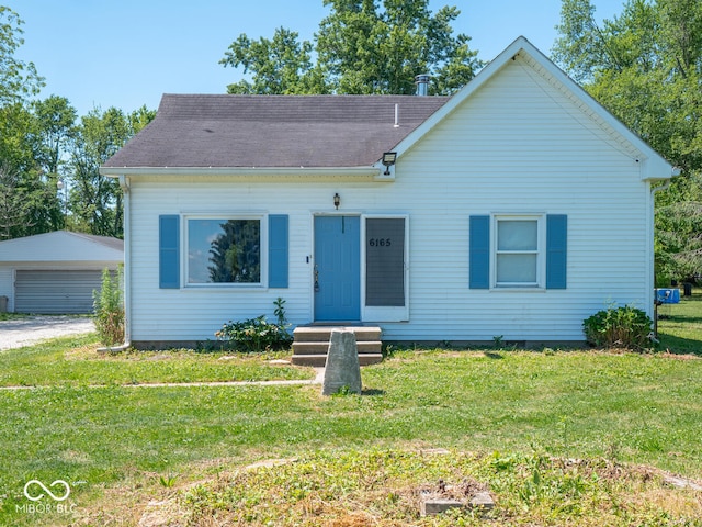 view of front of house featuring an outdoor structure, a garage, and a front lawn