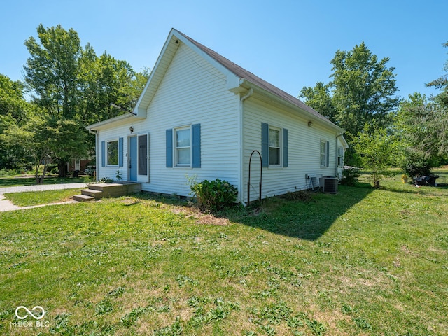 view of property exterior with central AC and a lawn