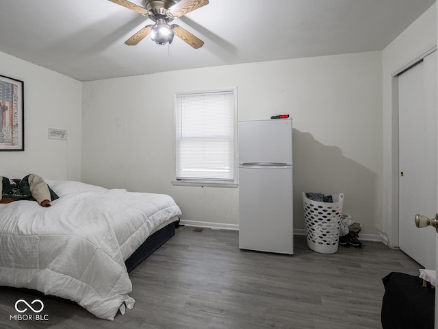 bedroom featuring white refrigerator, ceiling fan, and hardwood / wood-style floors