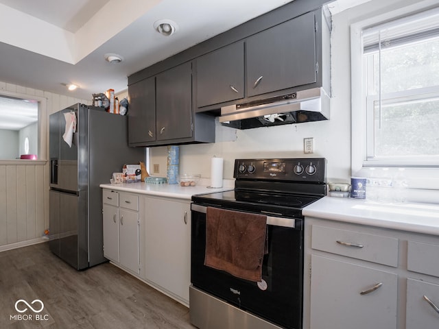 kitchen featuring stainless steel fridge with ice dispenser, light hardwood / wood-style floors, and electric range oven