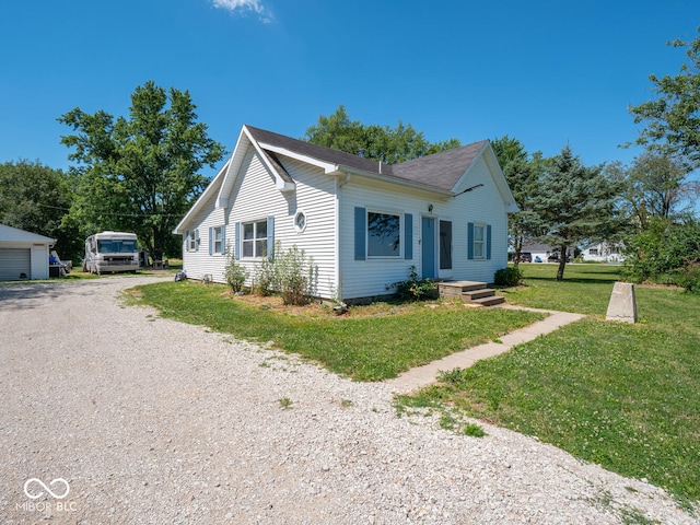 view of front facade featuring a garage, an outdoor structure, and a front yard