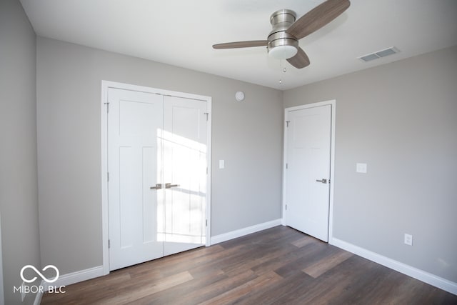 unfurnished bedroom with ceiling fan, dark hardwood / wood-style floors, and a closet