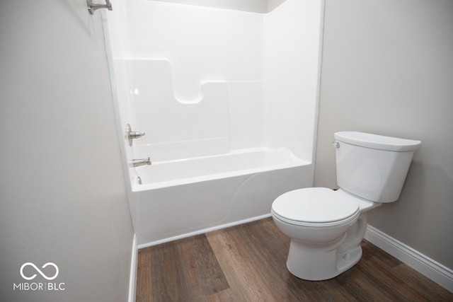 bathroom featuring hardwood / wood-style floors, toilet, and bathing tub / shower combination