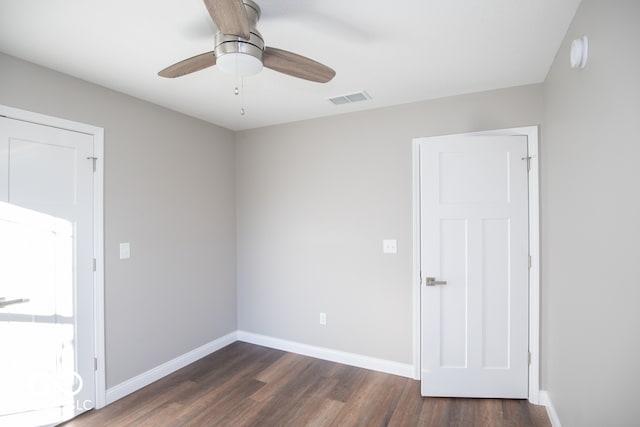 empty room with ceiling fan and dark hardwood / wood-style flooring