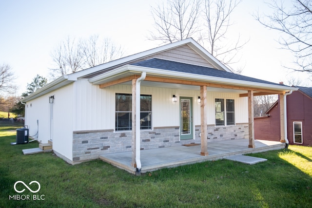 view of front of home featuring a front lawn, a porch, and central AC