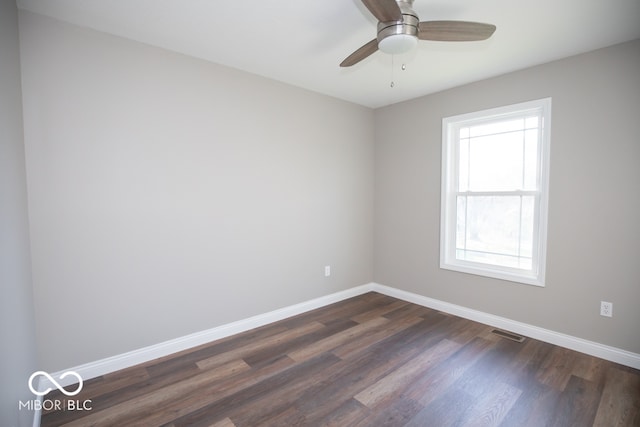 spare room with ceiling fan, a healthy amount of sunlight, and dark hardwood / wood-style floors