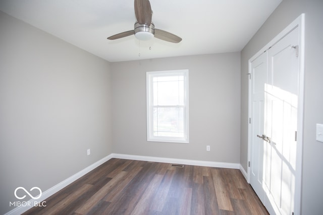 spare room with ceiling fan and dark hardwood / wood-style flooring