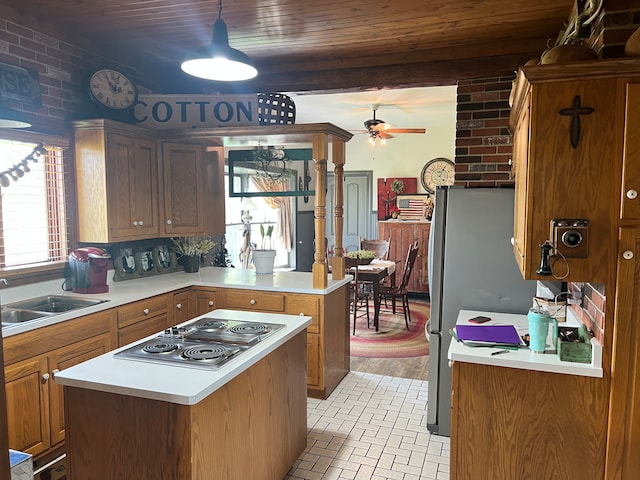 kitchen with a kitchen island, light hardwood / wood-style flooring, stainless steel gas stovetop, ceiling fan, and sink