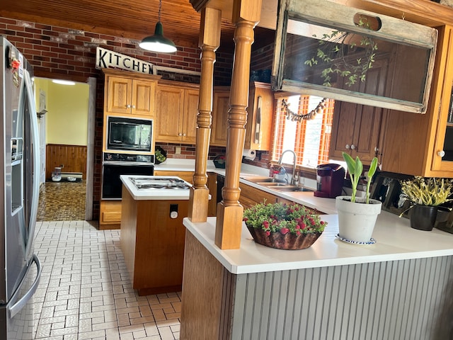 kitchen featuring decorative light fixtures, a kitchen island, backsplash, black appliances, and sink