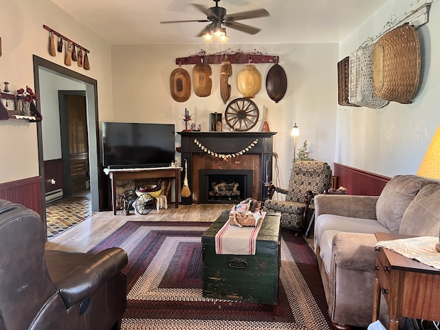 living room with a baseboard radiator, ceiling fan, and hardwood / wood-style flooring