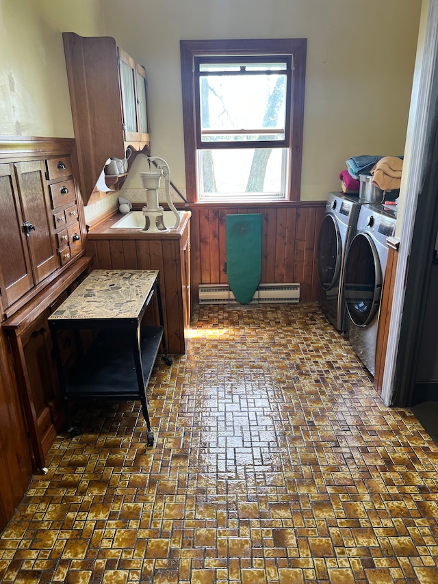 clothes washing area featuring independent washer and dryer and a baseboard heating unit